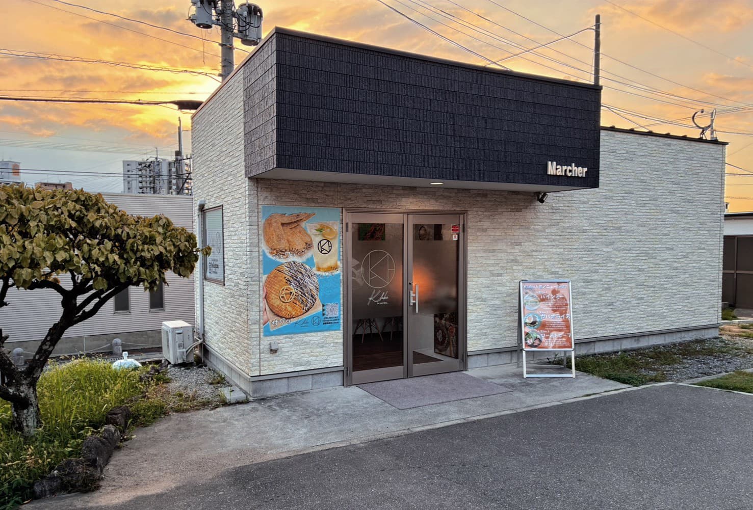 夕暮れのK-laboの外観。入口にメニューの看板が置かれている